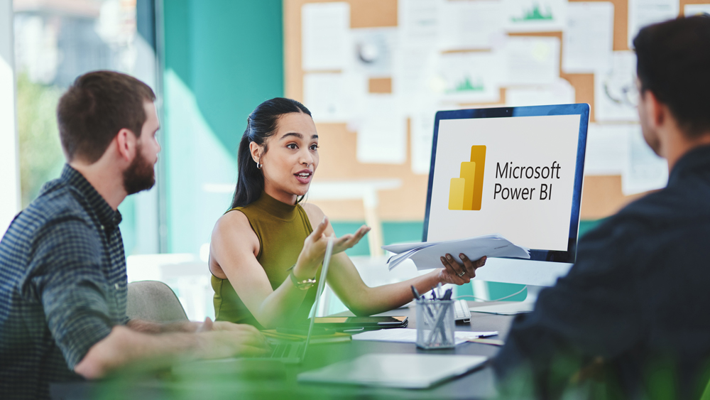 Menschen im Meeting mit Laptop mit dem Logo von Power BI, einem Business-Analytics-Dienst von Microsoft.