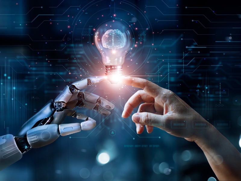 KI generiertes Bild einer menschlichen Hand und einer Roboter Hand, deren Finger sich berühren und eine Glühbirne in der Mitte, welche eine Idee symbolisiert.